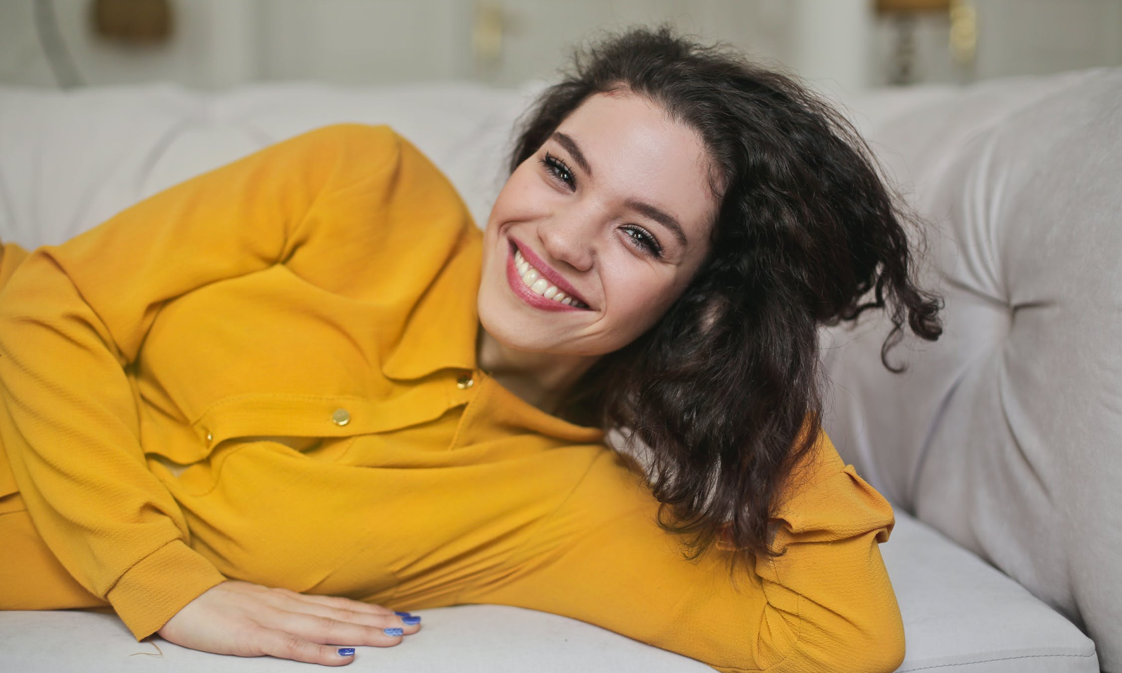 Woman Smiling Laying Down on a Sofa
