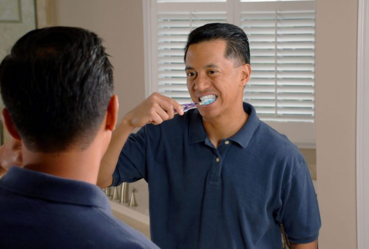 Man Brushing His Teeth Looking in The Mirror